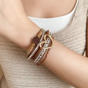 Close-up of a stylish multilayer leather bracelet with a resin heart and rhinestones