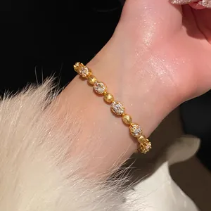 Elegant gold zircon oval link bracelet shown in close-up on a wrist with white fur