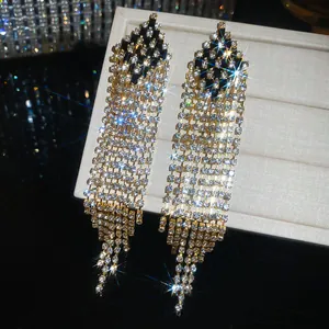 Close-up of silver needle diamond tassel earrings with sparkling crystal rhinestones.