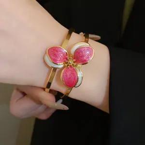 Detail of vintage floral bangle with pink and white enamel petals on a golden band
