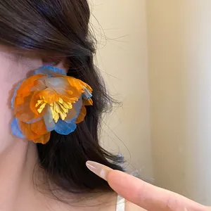 Detailed view of oversized orange and blue bohemian chiffon flower stud earrings
