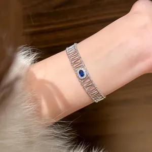 Close-up of elegant silver-colored bracelet with oval blue zircon on wrist.