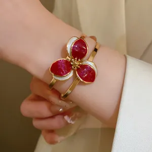 Close-up of elegant flower open bangle with red and white oil dripping enamel detail