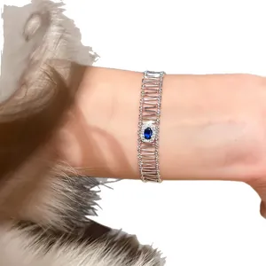 Elegant silver hollow zircon bracelet featuring an oval blue gemstone on a lady's wrist.