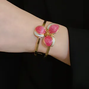 Detailed view of a retro enamel flower cuff bracelet with pink and white petals.