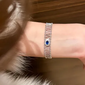 Detailed view of a vintage silver bracelet with a blue oval zircon on a wrist with fur sleeve