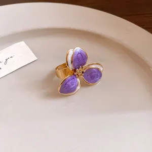 Elegant macro detail of a vintage purple enamel flower open ring with a gold finish