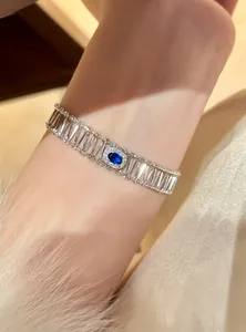 Close-up detail of luxury silver hollow bracelet featuring a blue oval zircon center.