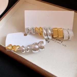 Detailed view of retro metallic heart and hoop earring set in gold and silver finishes for women.