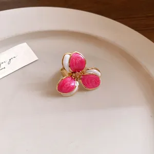 Detailed macro view of a vintage style metal ring with pink and white enamel flower