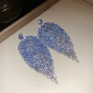 Detailed view of luxury silver needle earrings with light blue rhinestone diamond fringe