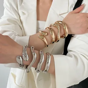 Fashionable chunky wavy metal bangles in gold and silver plating with textured finish.