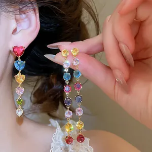 Vue détaillée des boucles d'oreilles pendantes en zircone colorée et plaqué or 18 carats