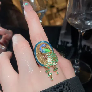 Close-up of vintage Neo-Chinese peacock open ring with gold filigree and enamel details
