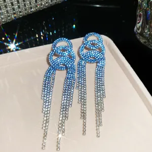 Detailed macro view of elegant blue rhinestone tassel earrings with sparkling starbursts