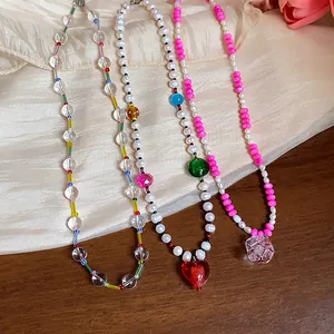Détail de colliers de perles faits main avec perles colorées et pendentifs cœur