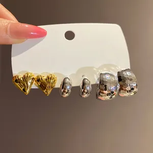 Detailed macro view of heart-shaped and textured hoop earring set on a display card