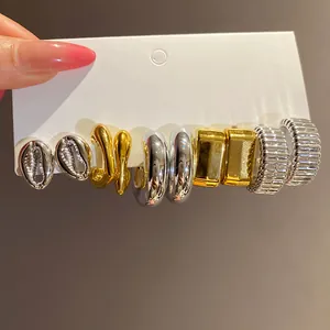 Detailed view of vintage gold and silver earring set on white display card