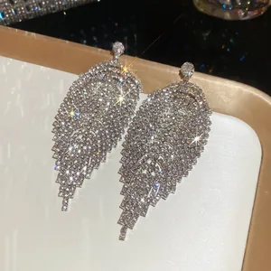 Detailed view of silver-toned rhinestone tassel earrings with sparkling leaf design