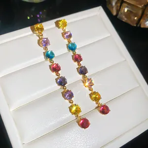 Détail macro de boucles d'oreilles pendantes avec zircons colorés plaqués or 18 carats