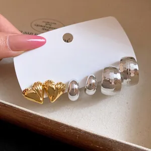Detailed view of vintage gold heart and silver hoop earring set on a display card.