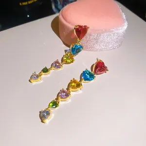 Détail de boucles d'oreilles pendantes en cœur de zircon coloré plaqué or 18 carats