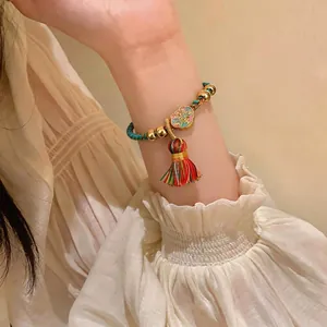 Farbig geflochtenes Seilarmband mit Goldperlen und einem Wolken-Quastenanhänger