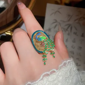 Detailed view of an 18K gold plated peacock ring with green and blue enamel details.