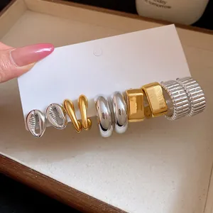 Detailed close-up of mixed gold and silver vintage earring set on white display card