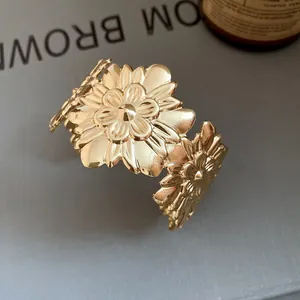 Detail view of gold metal cuff bracelet with elegant wrinkled floral design