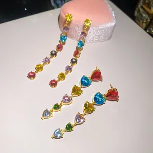Vue détaillée de boucles d'oreilles en cœur et rondes en zircone colorée plaqué or 18K.