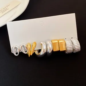 Detailed view of assorted gold and silver fashion earring set on white display card