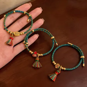 Detailaufnahme von drei farbenfroh geflochtenen Seilarmbändern mit traditionellen Anhängern.