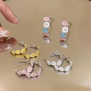 Macro view of sweet silver needle enamel flower C-hoop earrings with zircon centers