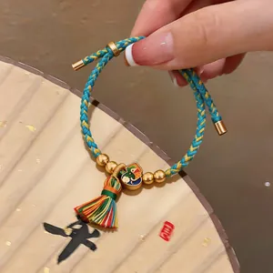 Nahaufnahme eines bunten Drachenbootfest-Armbands mit Quaste und Emaille-Anhänger-Detail