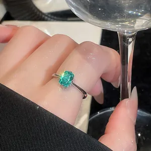 Detailed close-up of a vintage square green gemstone ring worn on the index finger.