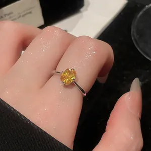Detailed view of a vintage-style silver ring featuring a radiant yellow oval gemstone.
