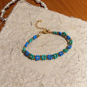 Macro del bracciale vintage in perle di vetro blu e verde acqua con chiusura dorata