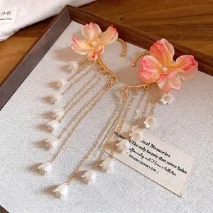 Eleganti earcuff a fiori in tessuto con lunghe nappe di perle e ciondoli a campanula.