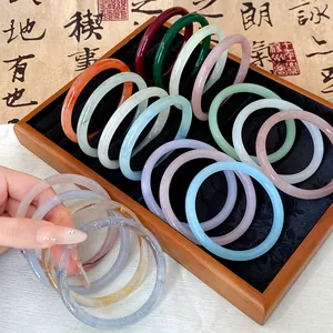 Detailed view of colorful translucent jade-style glass bangles in various shades