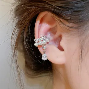 Detailed close-up of a zircon and pearl ear cuff featuring a dangling teardrop stone