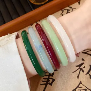 Close-up of five multi-colored glass jade-like bangles on wrist for Hanfu style