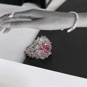 Macro view of a luxury ring with a large pink zircon center stone and silver finish.