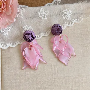 Detailed view of the handcrafted purple fabric rose and pink acrylic petal drop earrings