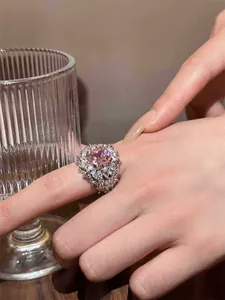 Close-up of a luxury ring featuring a large pink square-cut zircon and clear accents