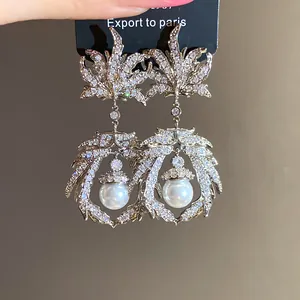 Detailed view of vintage zircon maple leaf drop earrings with elegant pearl accents