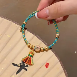 Nahansicht eines bunten geflochtenen Drachenbootfest-Armbands mit Quaste und Anhänger.