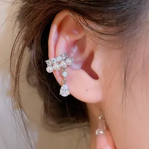 Detailed macro shot of silver ear cuff decorated with white pearls and teardrop zircon