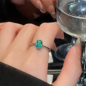 Close-up of a vintage-style square teal gemstone ring on an adjustable silver band