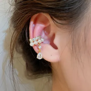 Close-up of an elegant gold ear cuff featuring pearls and a teardrop zircon on ear